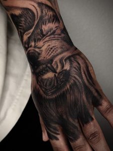 Realistic black and grey wolf hand tattoo by Legendary Tattoos in Las Vegas.