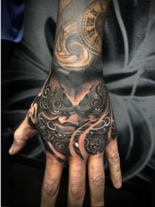 Dragon mask hand tattoo with clock forearm design by Wally at Legendary Tattoos