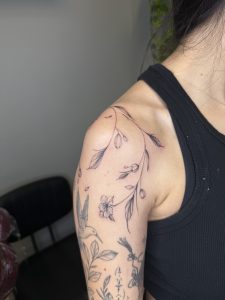 Elegant "Breathing" script tattoo on forearm, showcasing fine line work.