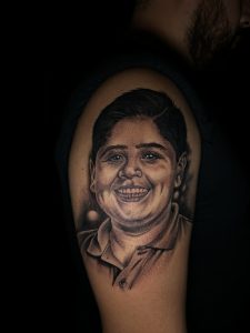 black and grey portrait tattoo of his nephew