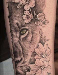 Lioness Tattoo with flowers on the face of the animal by Lisset Raven Cabrera in Las Vegas at Legendary Tattoos.