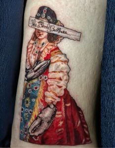 The Blood Brothers band tattoo of their album cover Burn, Piano Island, Burn by Lisset Raven Cabrera at Legendary Tattoos.