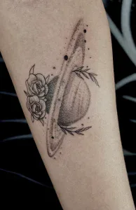 A tattoo of a saturn and roses on the arm. This tattoo was done at Legendary Tattoos in Las Vegas Nevada.