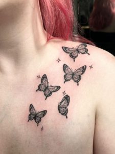 Shoulder Butterfly Tattoo by Isabella Roberts at Legendary Tattoos in Las Vegas, Nevada. The butterfly tattoo is on her front shoulder area and the women has pink hair as well.