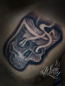 Skull Tattoo by Wally at Legendary Tattoo in Las Vegas, Nevada. In this skull tattoo, the skull is also shapped like a wad of cash and the eye sockets of the skull have smoke coming out of them.
