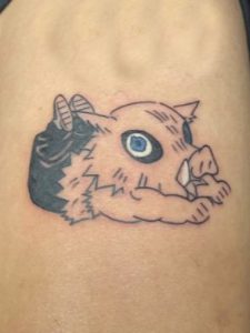 A tattoo of Inosuke Hashibira from Demon Slayer.