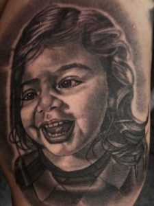 A portrait of a baby laughing, very detailed in black and grey.